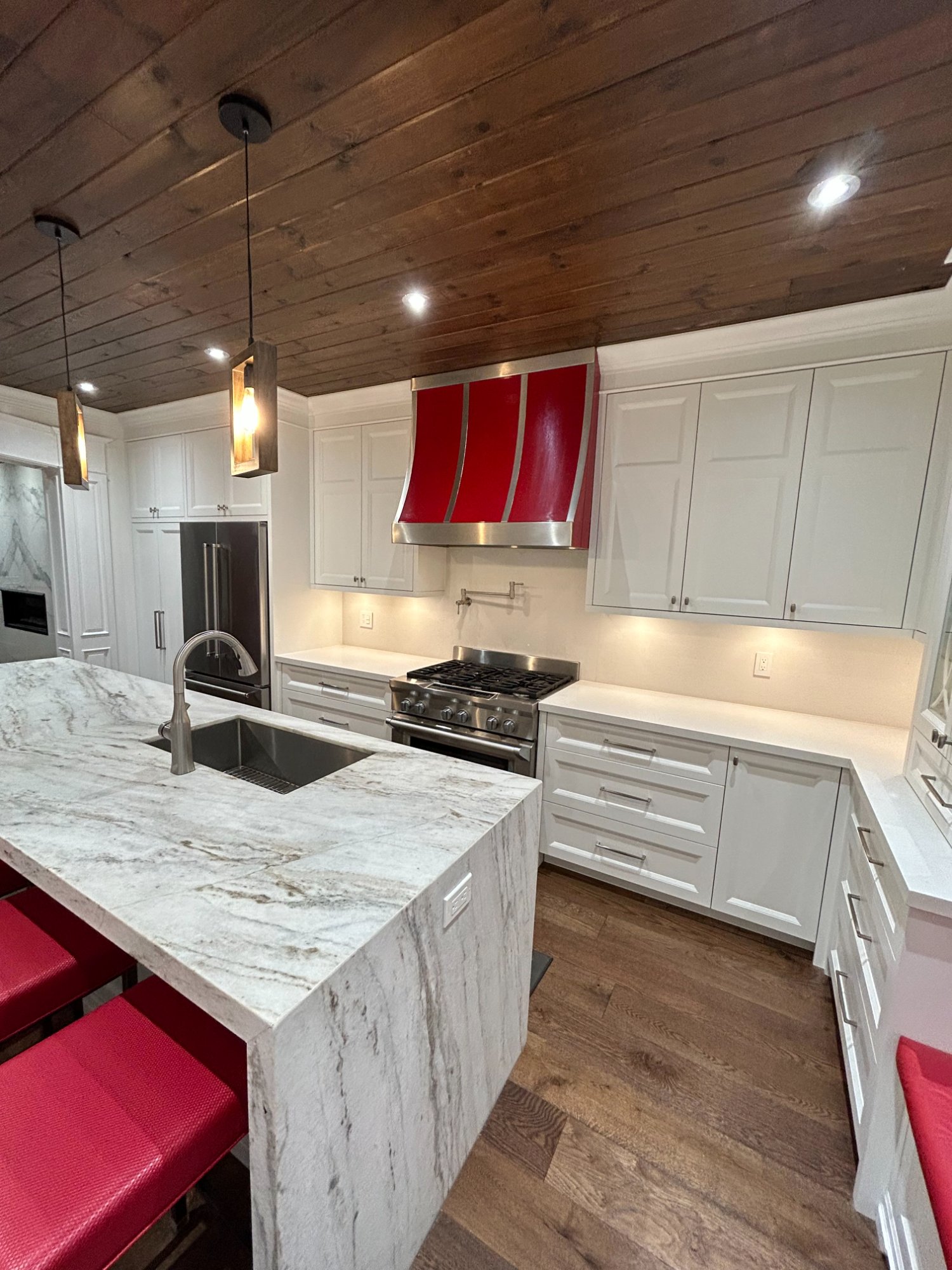 Custom kitchen with marble island and wood ceiling