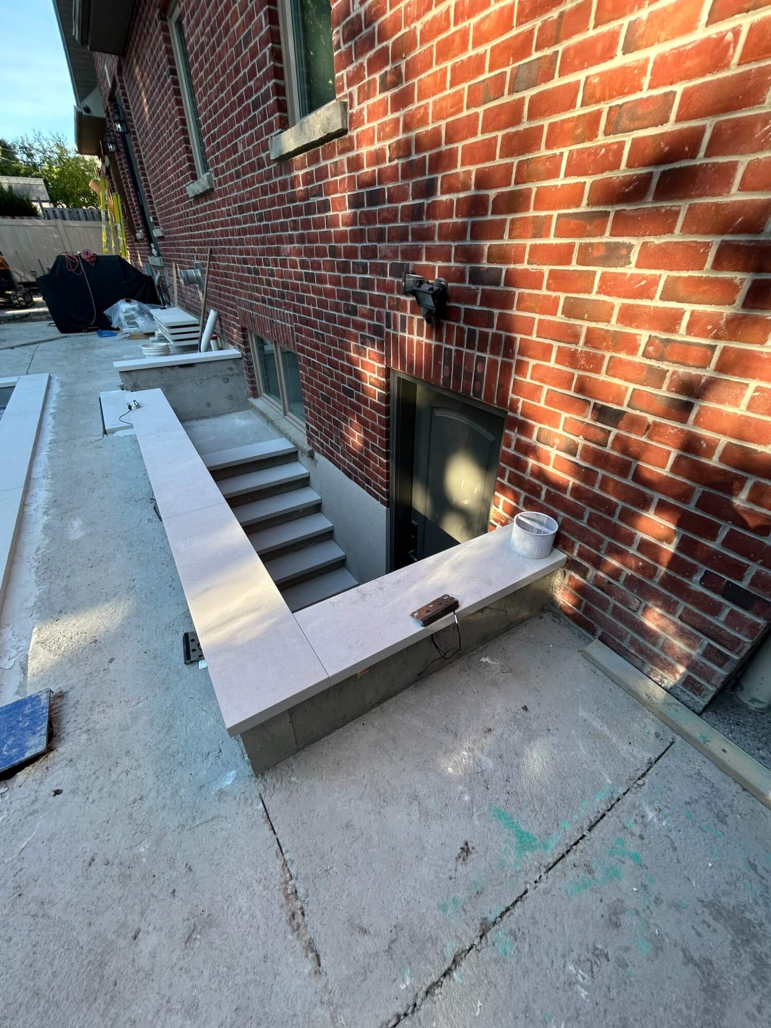 Basement walkout with concrete stairs and retaining walls